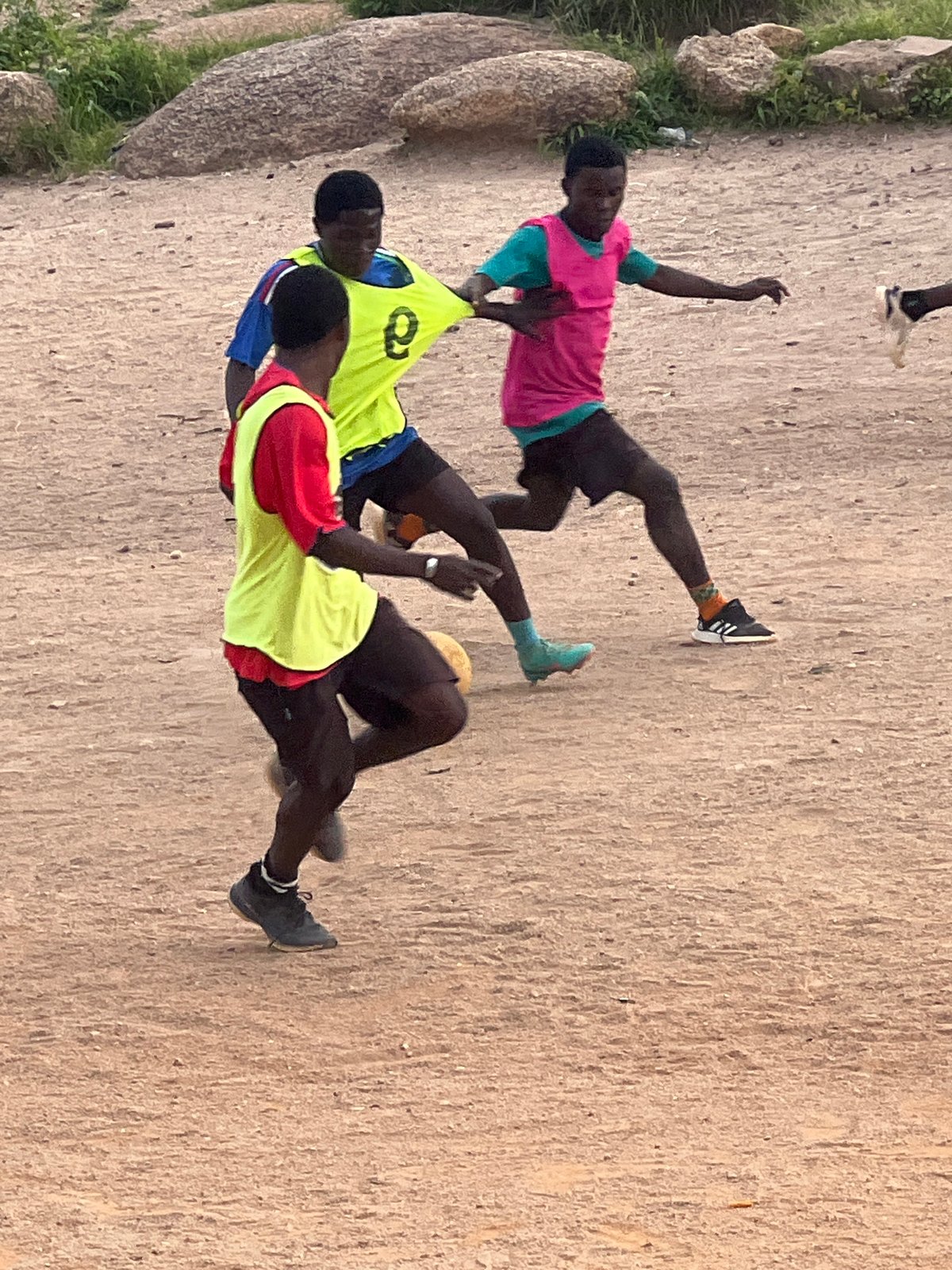 Pick-up football on a rocky dirt pitch in Jos, Nigeria
