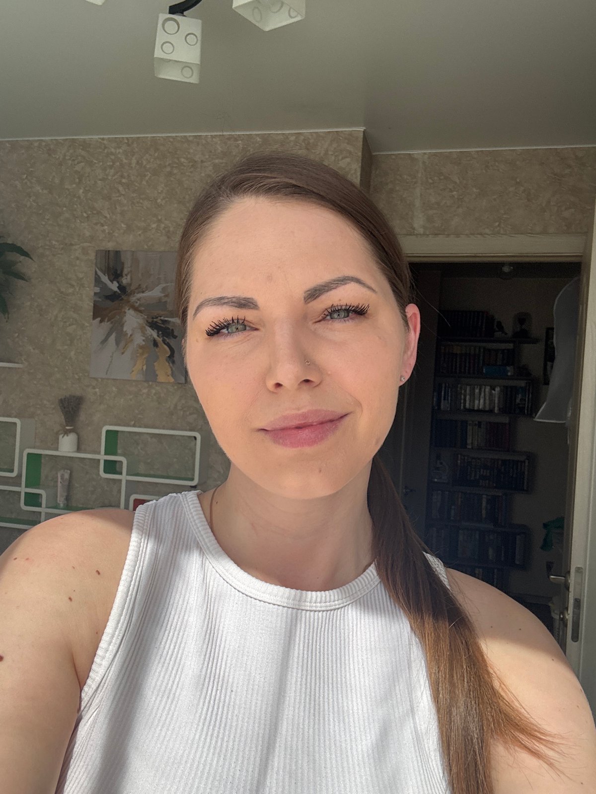 Woman in white tank top captured in close-up portrait