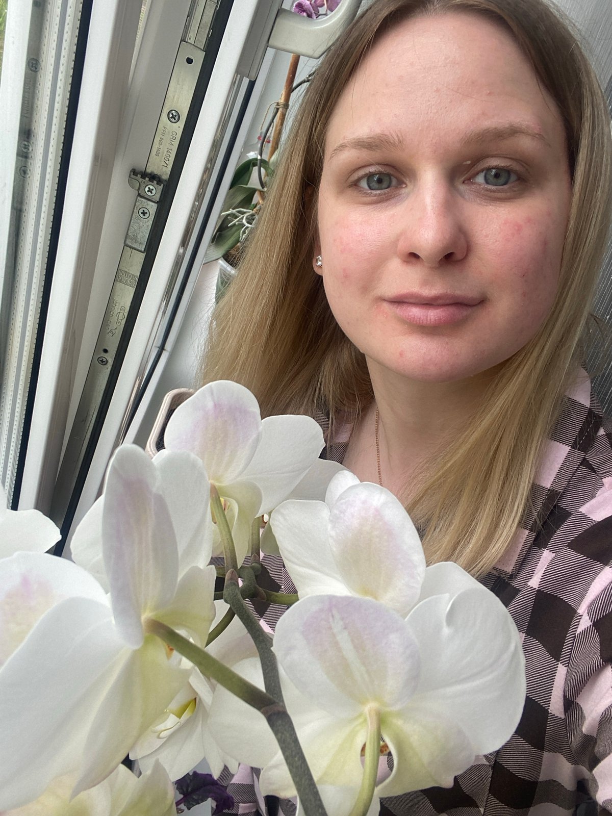 Woman poses with orchids in Russian home