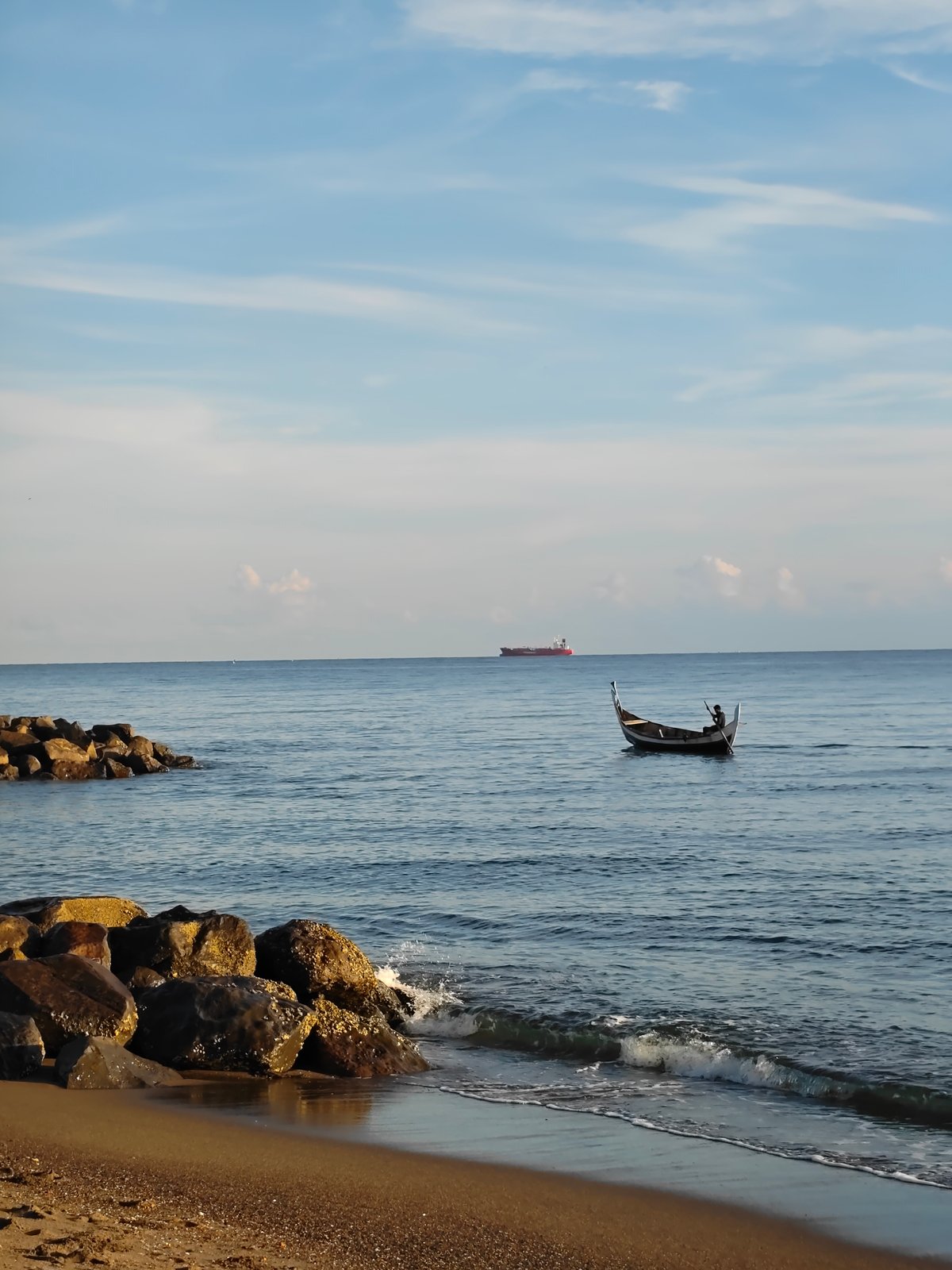 Fisherman rows traditional boat near Lhokseumawe coast