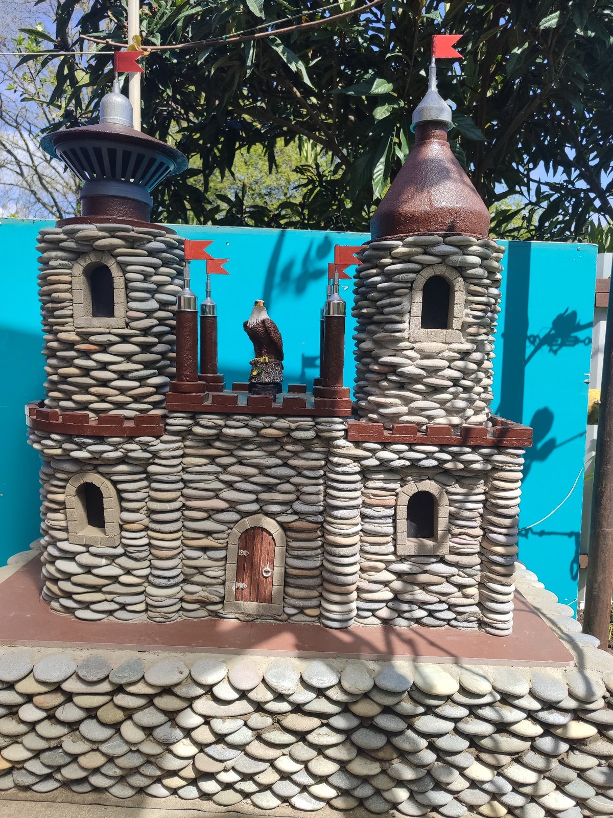 Decorative stone castle with eagle statue spotted outdoors