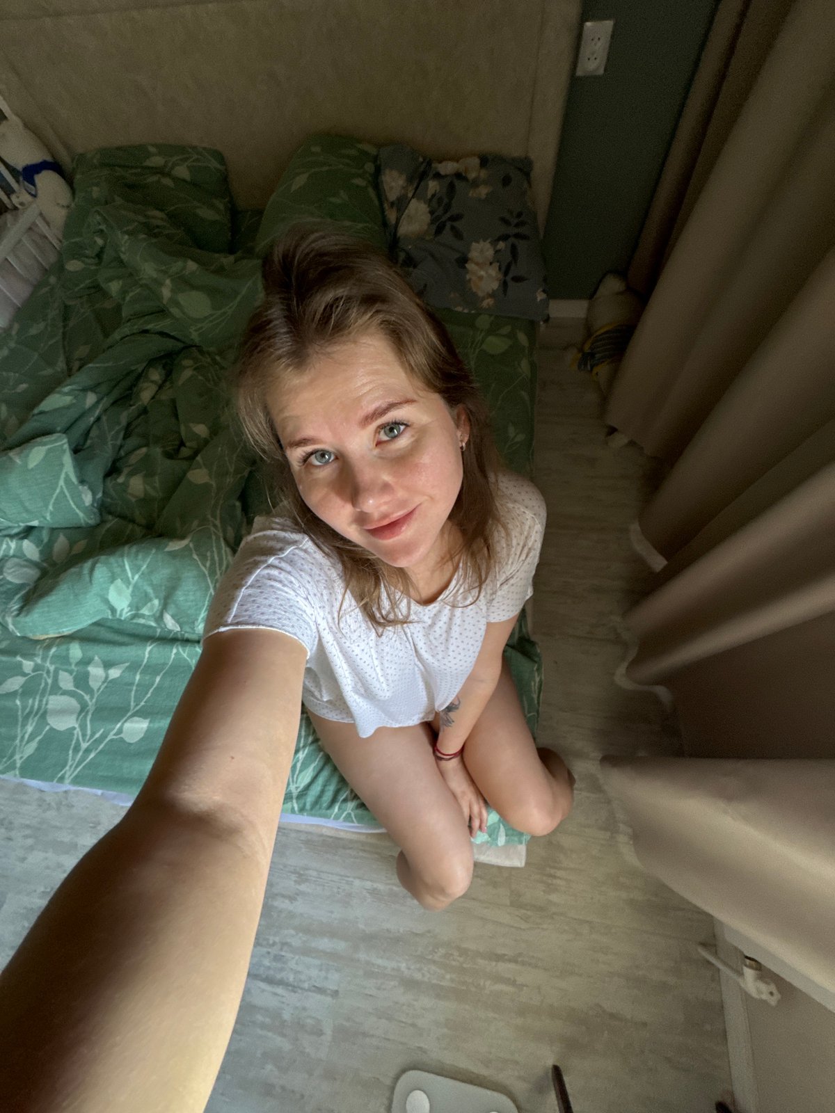 Woman poses for photos on bed in Russia