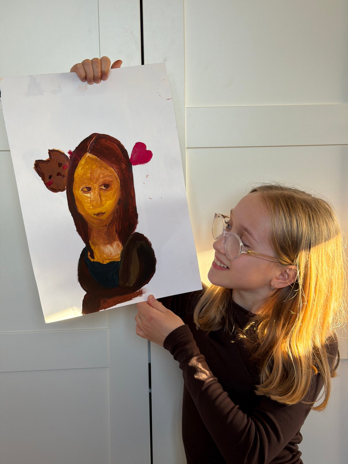 Young artist displays painting indoors in Dreiliņi, Latvia