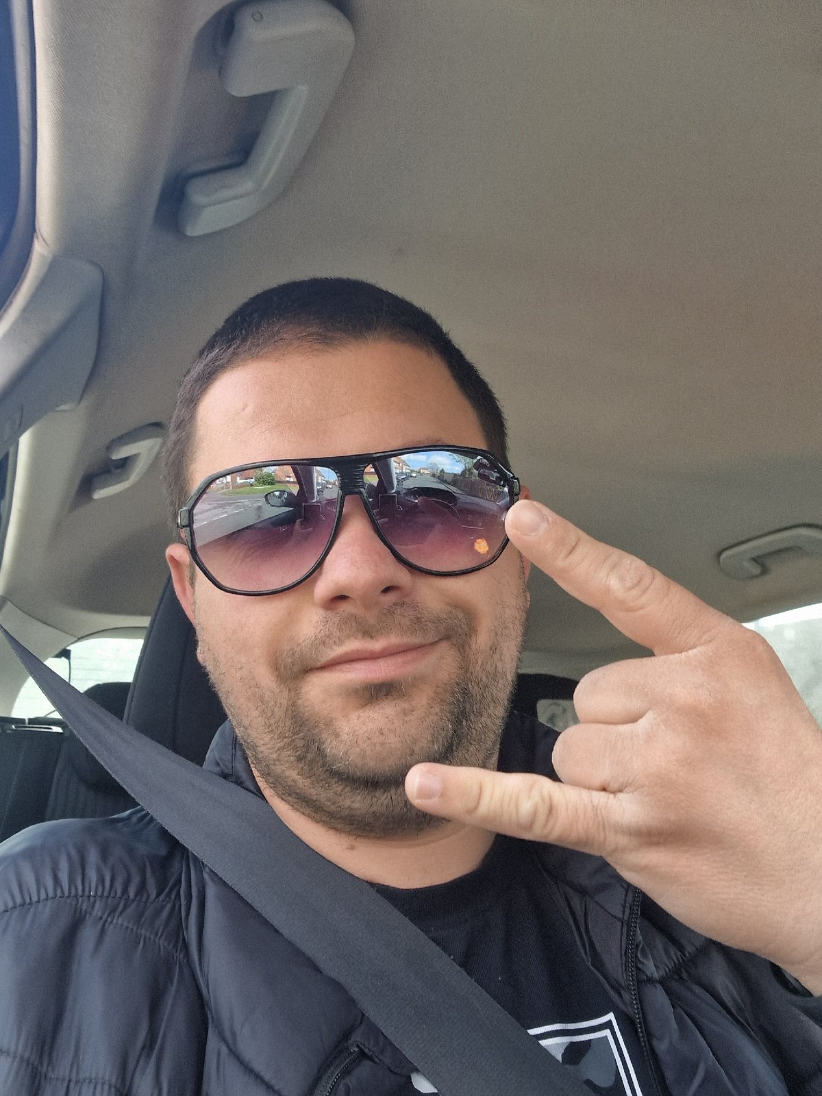 Man makes rock gesture in car passenger seat