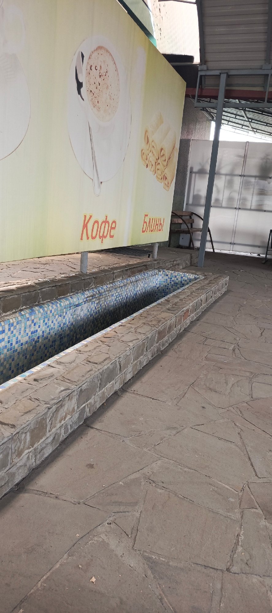 Tiled water feature and covered seating in Kamenolomni plaza