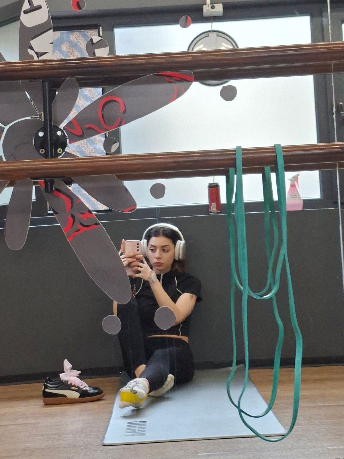 Woman records selfie on yoga mat with headphones