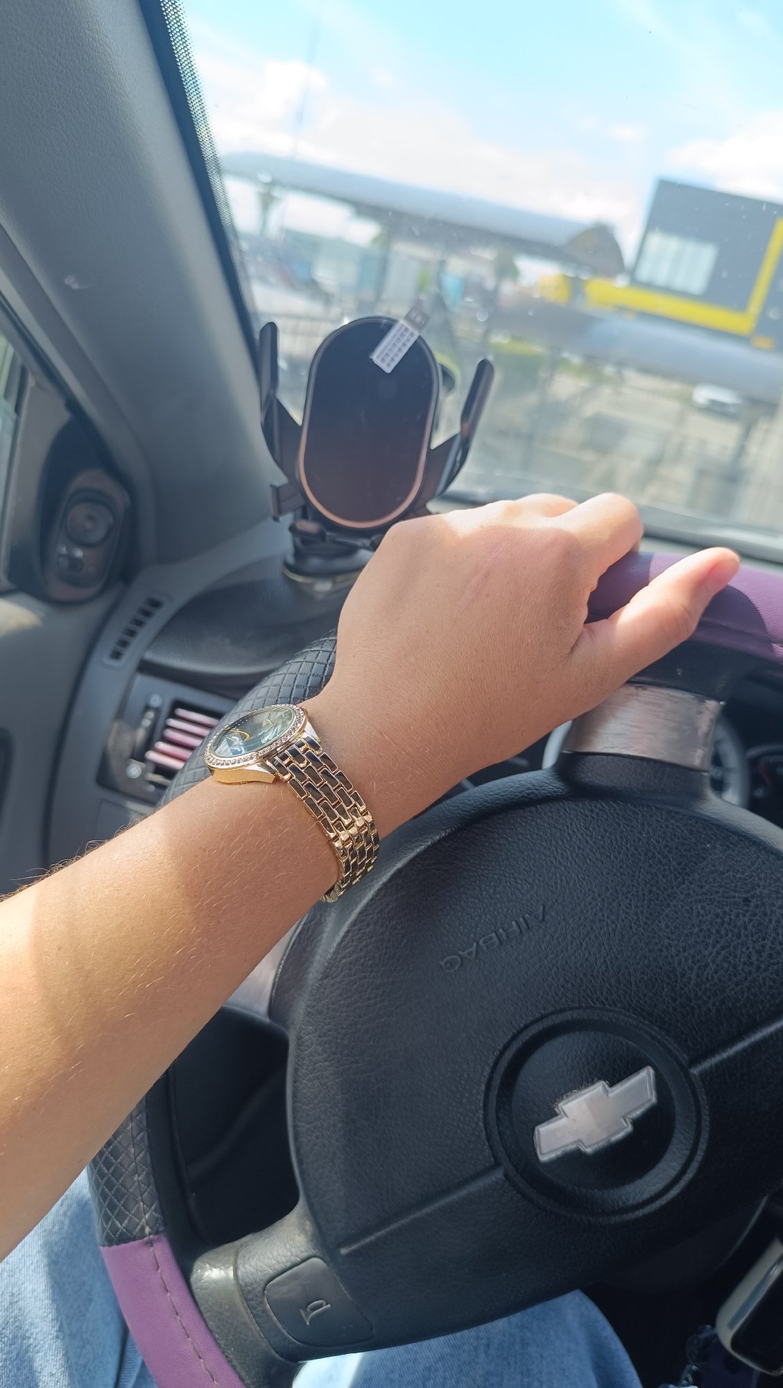 Inside a car in Chaikovsky, gold watch on the wheel