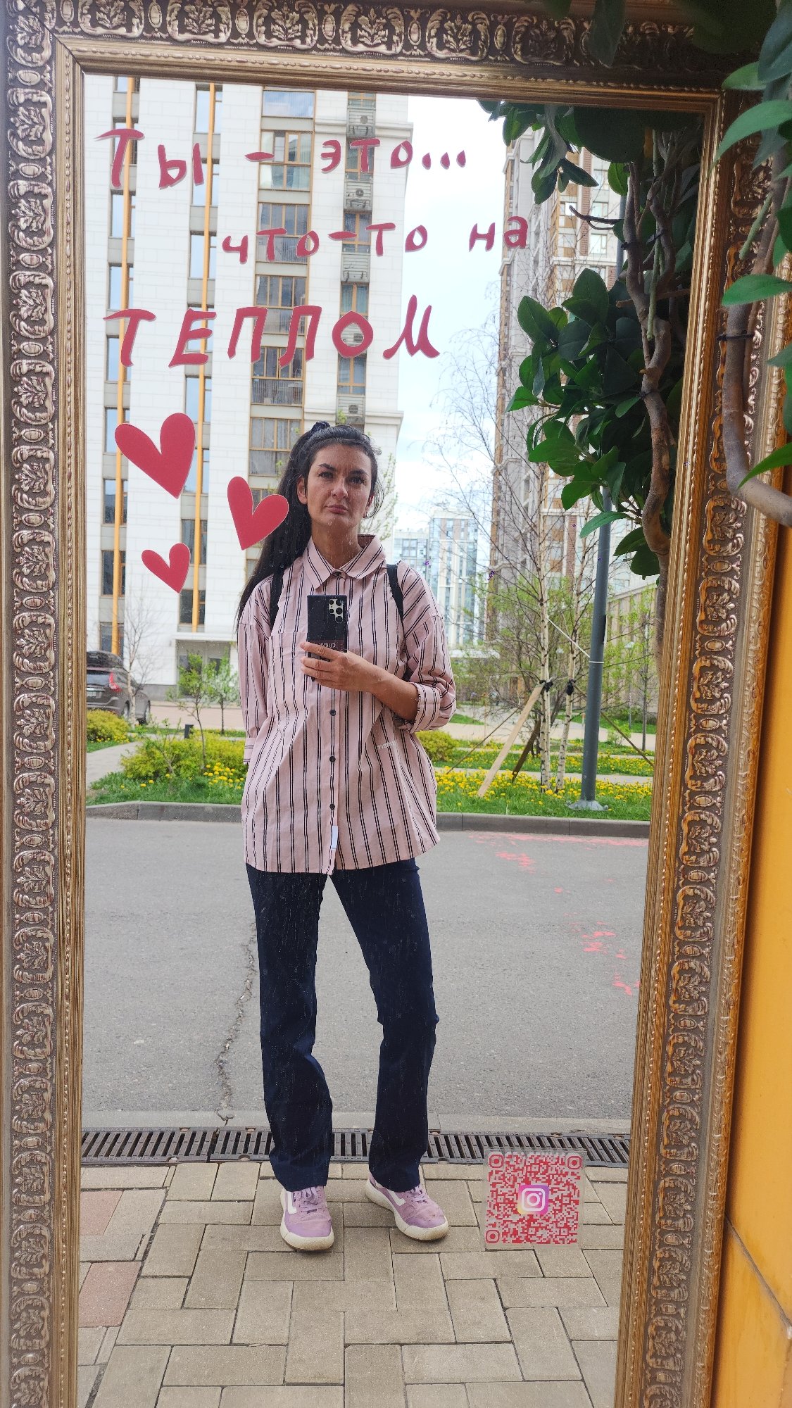 Woman in striped shirt observed in ornate mirror, Moscow