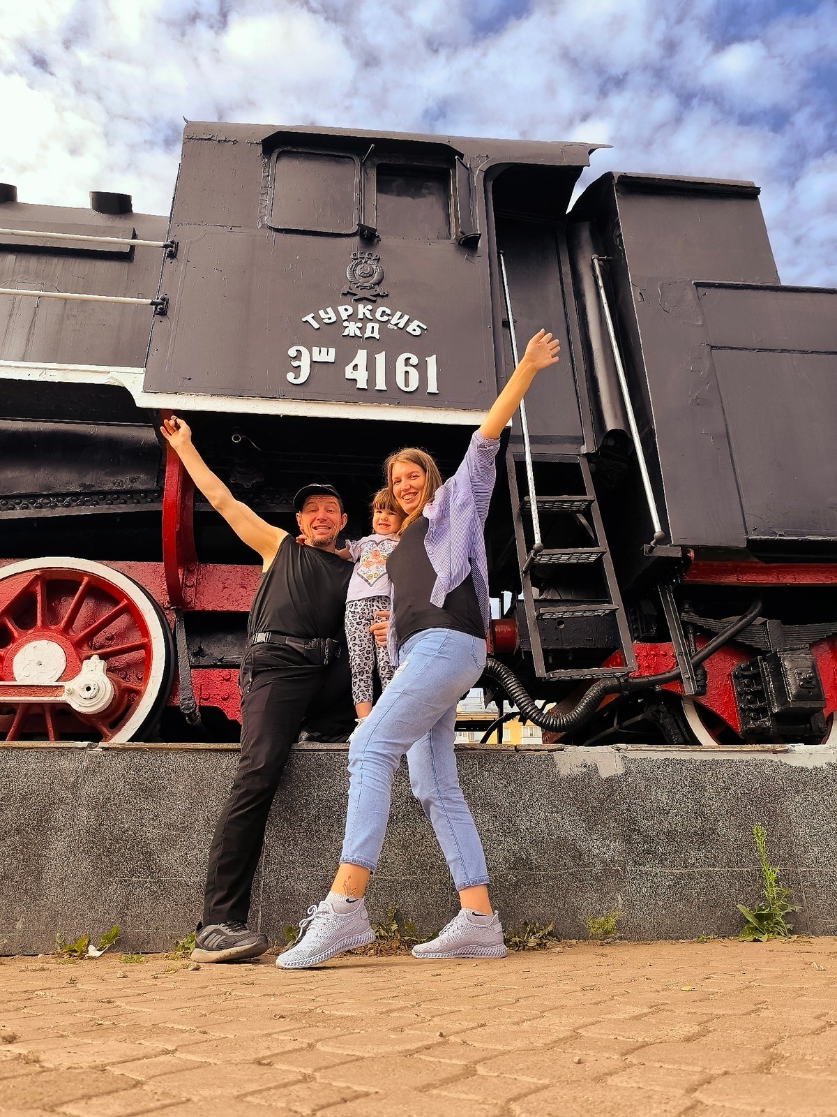 Posing beside a vintage steam locomotive monument in Astana