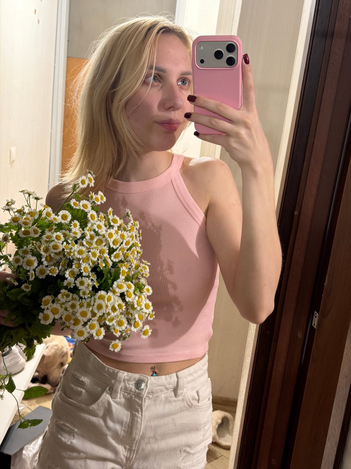 Mirror selfie with white daisy bouquet in Moldovan home