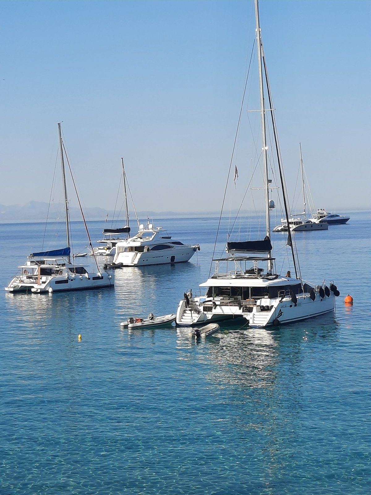 Yachts anchored in the blue waters of Platys Gialos, Greece