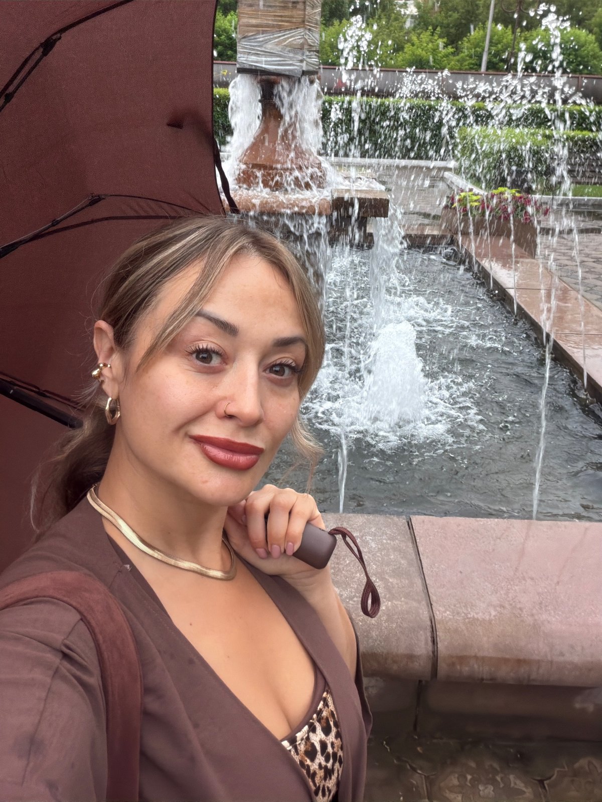 Quick sunny moments by a Krasnoyarsk fountain, pink umbrella in tow