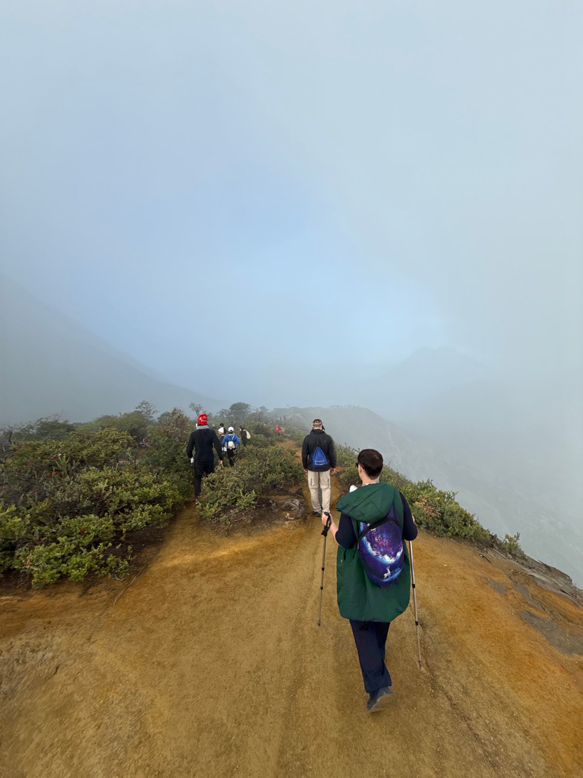 Hikers navigate foggy mountain trail in Indonesia