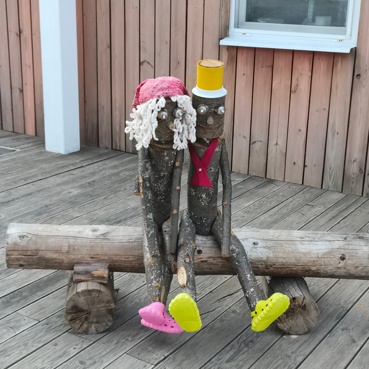 Handmade wooden folk art figures on a bench in Chaikovsky