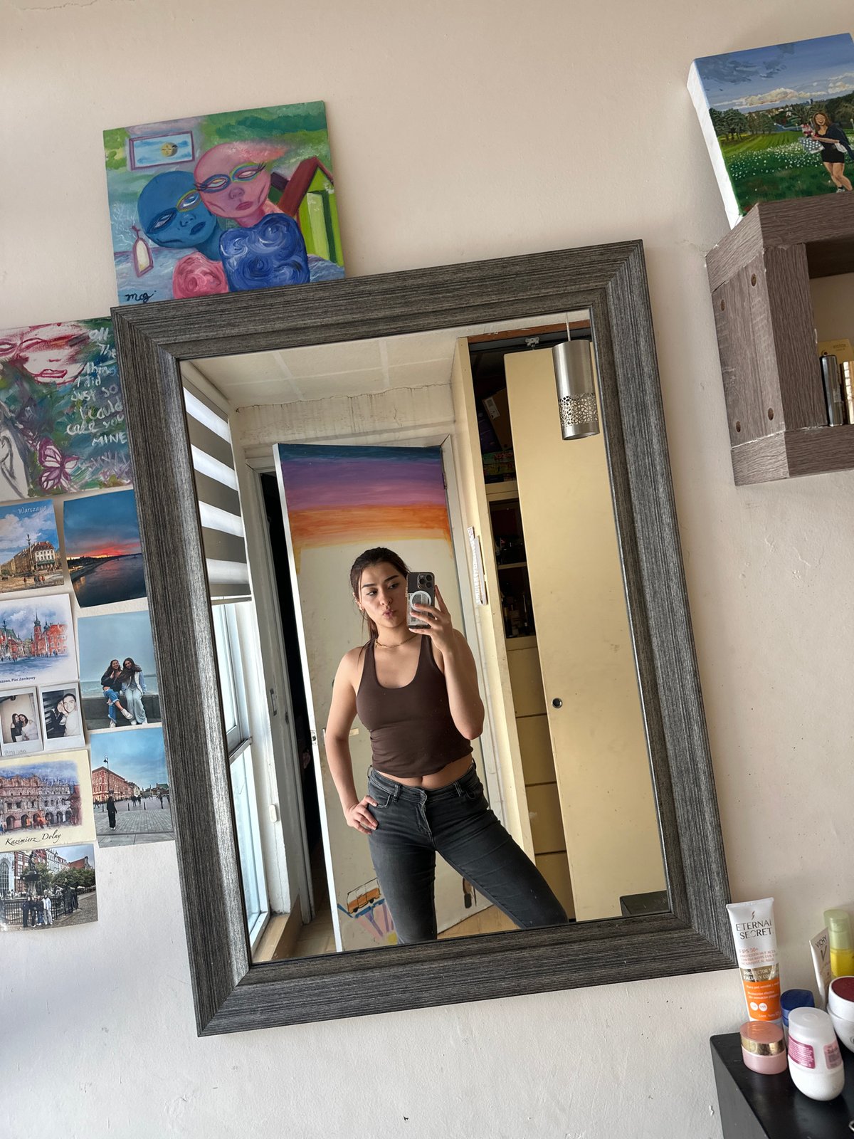 Woman takes mirror selfies in bedroom in Puebla