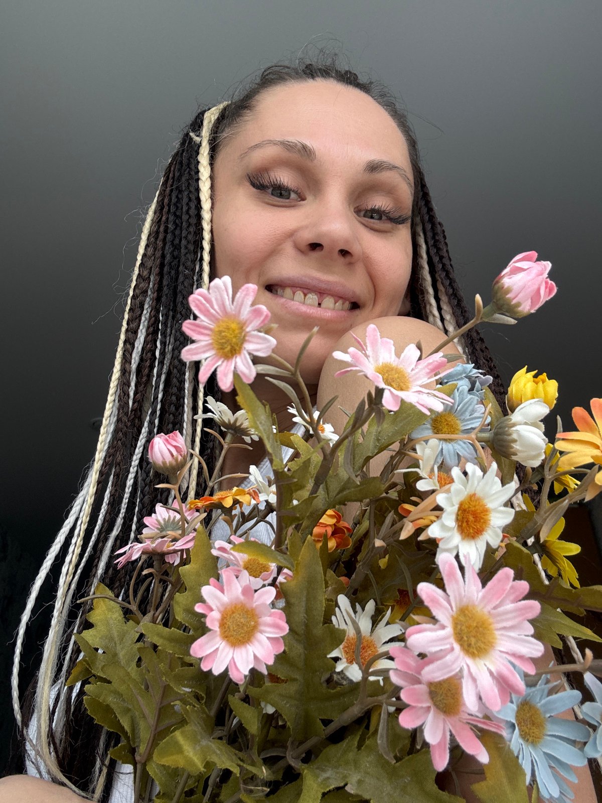 Woman holds colorful artificial flower bouquet in Rusanovo