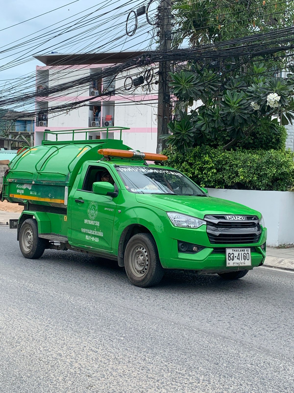Garbage and Coca-Cola trucks parked on a Ko Samui street