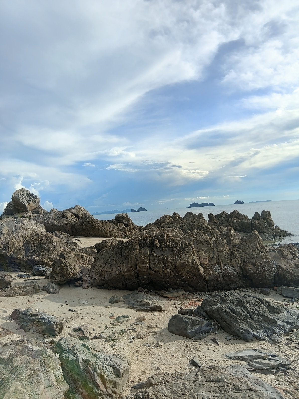 Temple blessings and rocky coastline at Baan Taling Ngam
