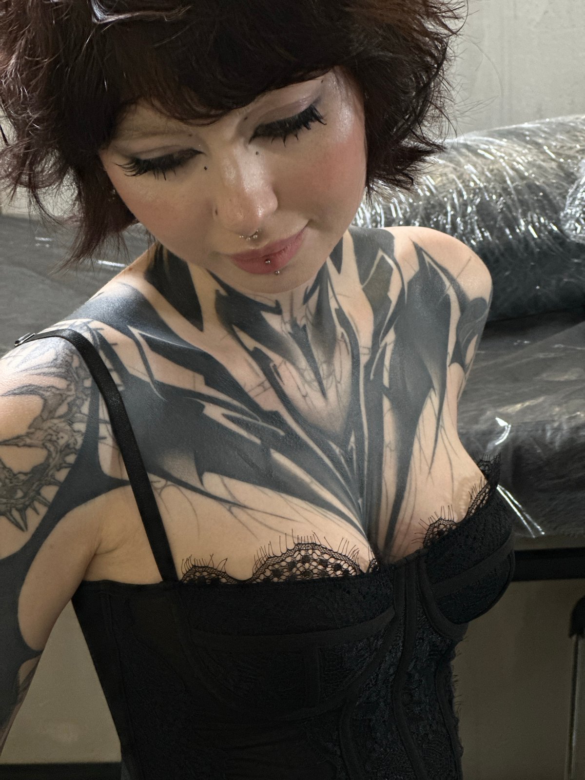 Tattooed woman in black clothing observed in Moscow tattoo studio