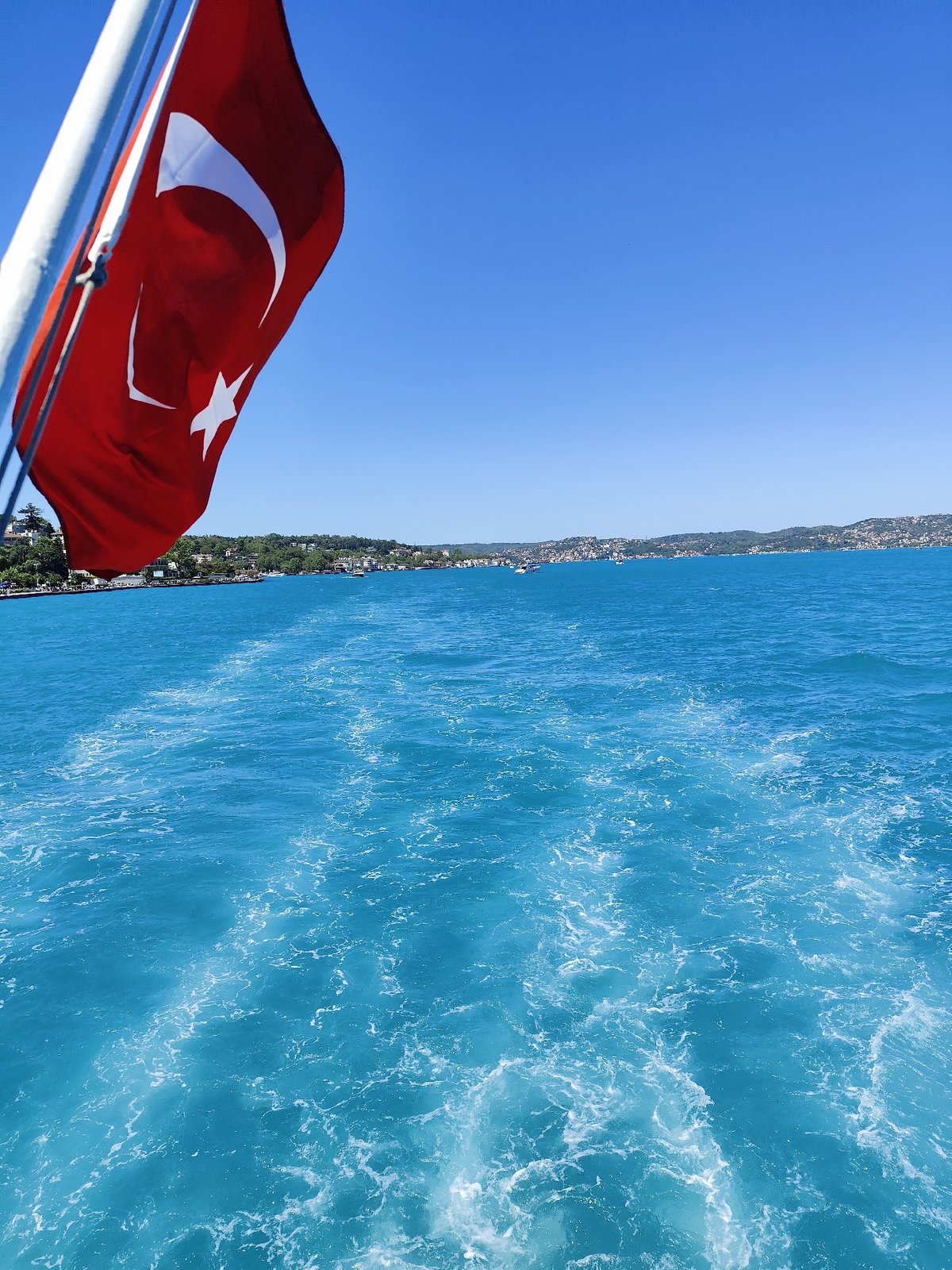 Boats navigate sunny Bosphorus waters near Sarıyer, Turkey