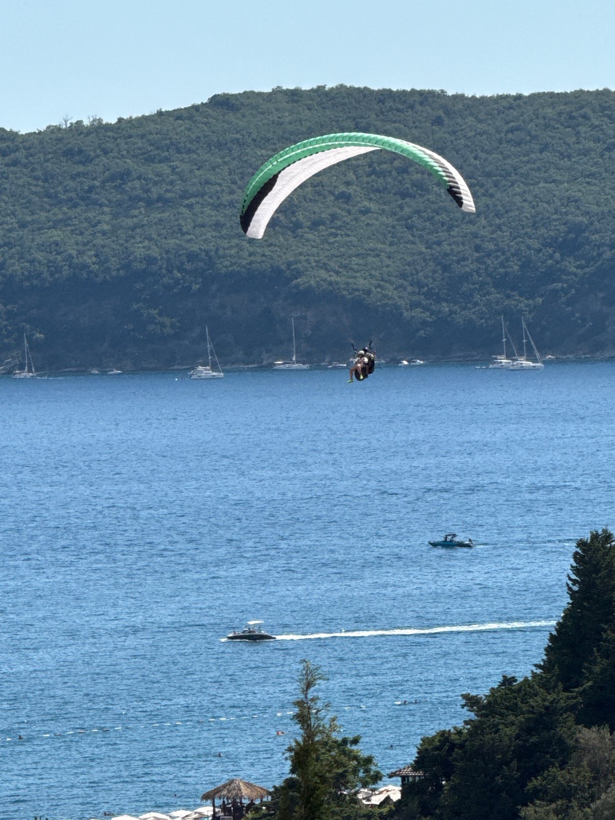Paragliders ride thermals above the Adriatic coast at Boreti