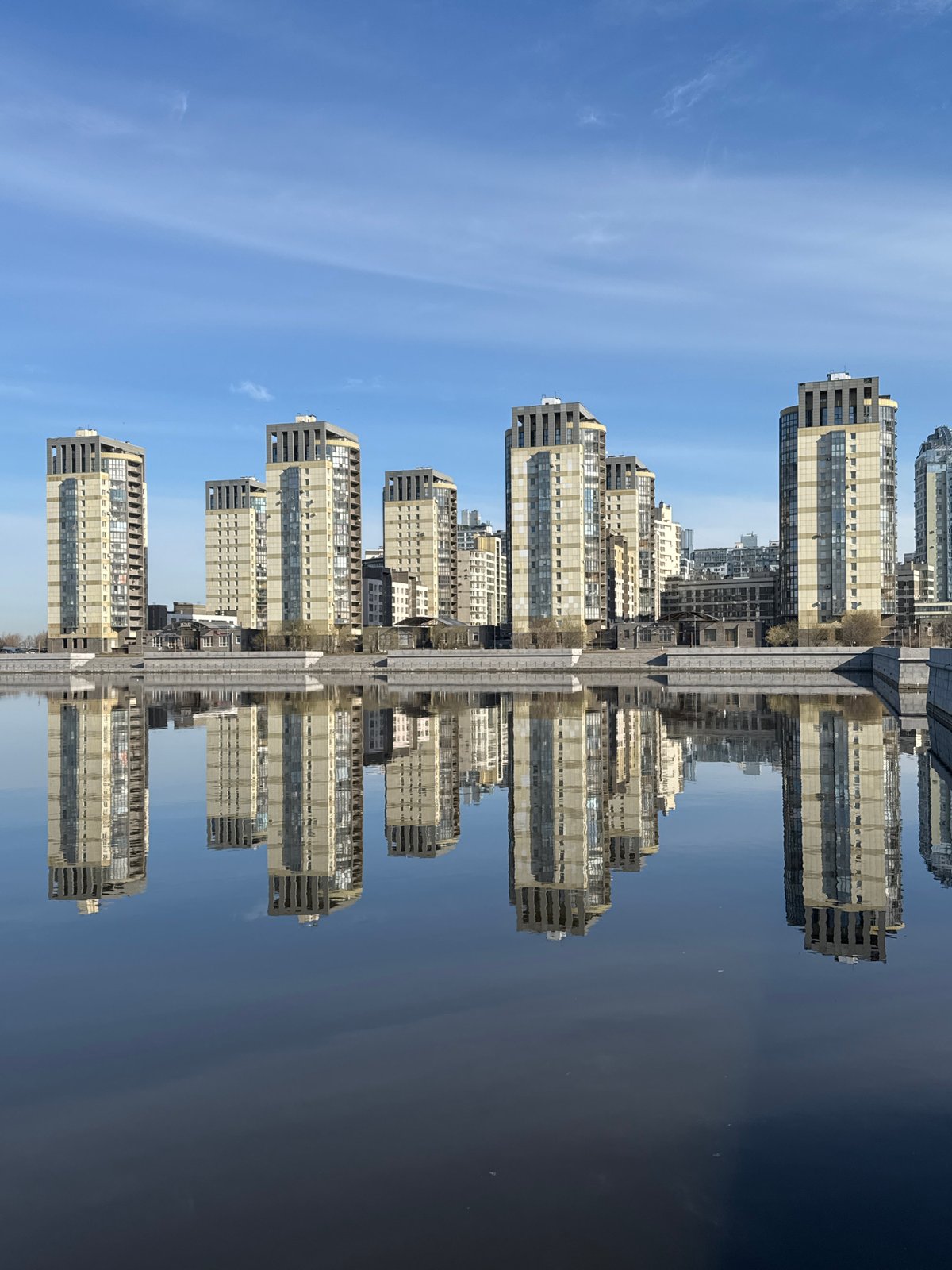 Morning reflection captures apartment buildings mirrored in Saint Petersburg waters