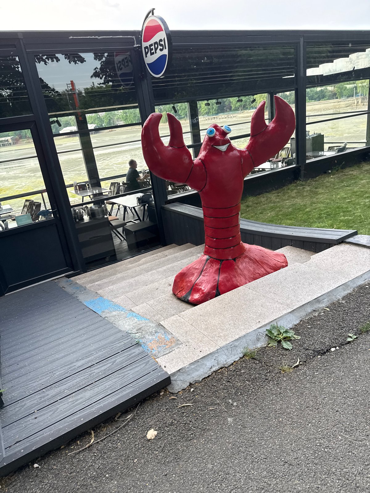 Red lobster sculpture and a drying algae-covered lakebed in Bucharest