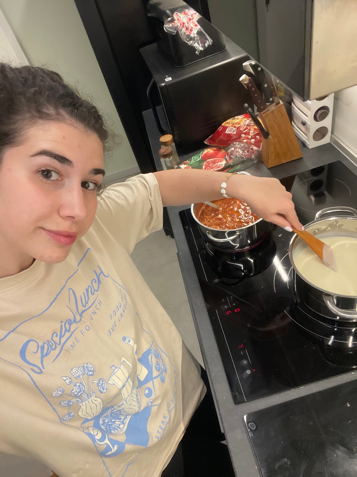 Woman takes kitchen selfies while feeding cucumber to poodle