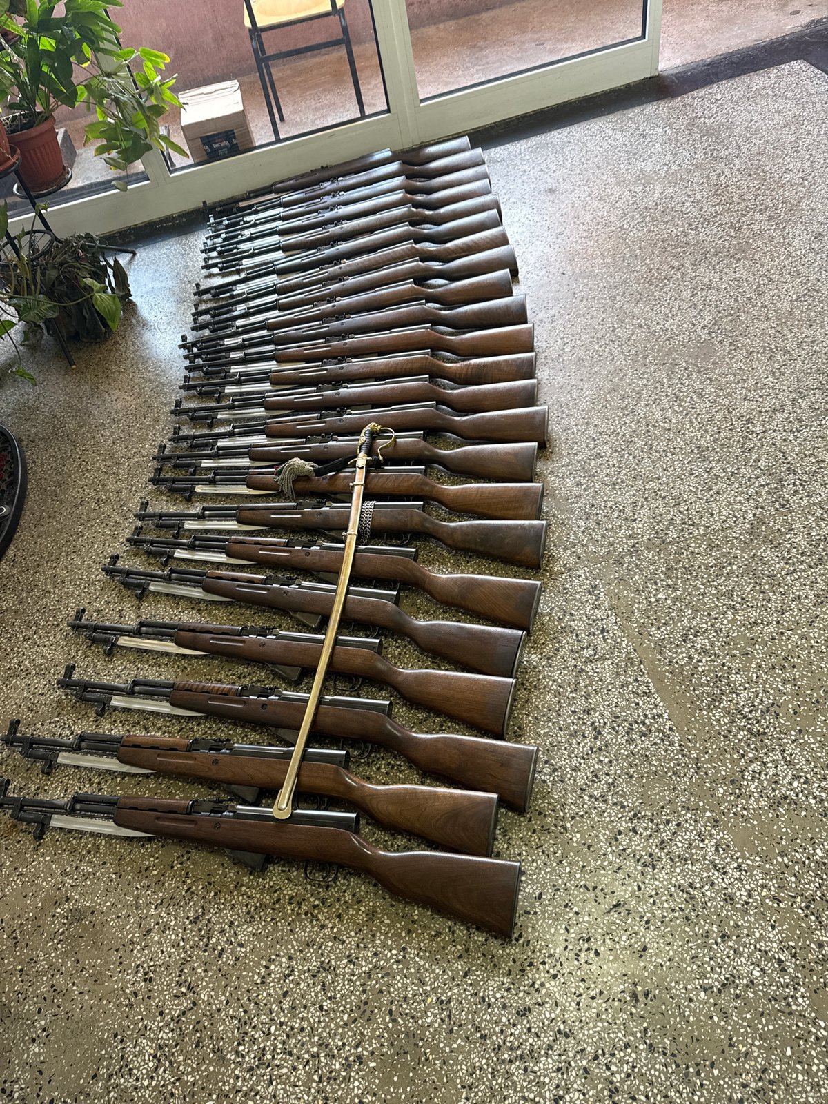 Rifle collection with ceremonial sword displayed on Sofia wall