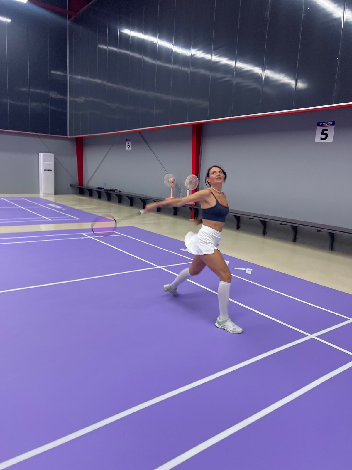 Woman plays badminton on indoor court in Ko Samui