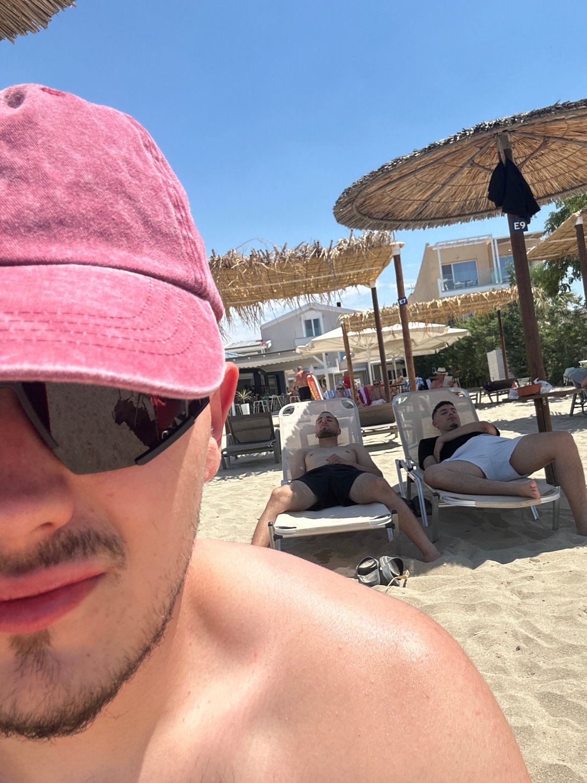 Lazy beach day under straw umbrellas, selfies and lounging