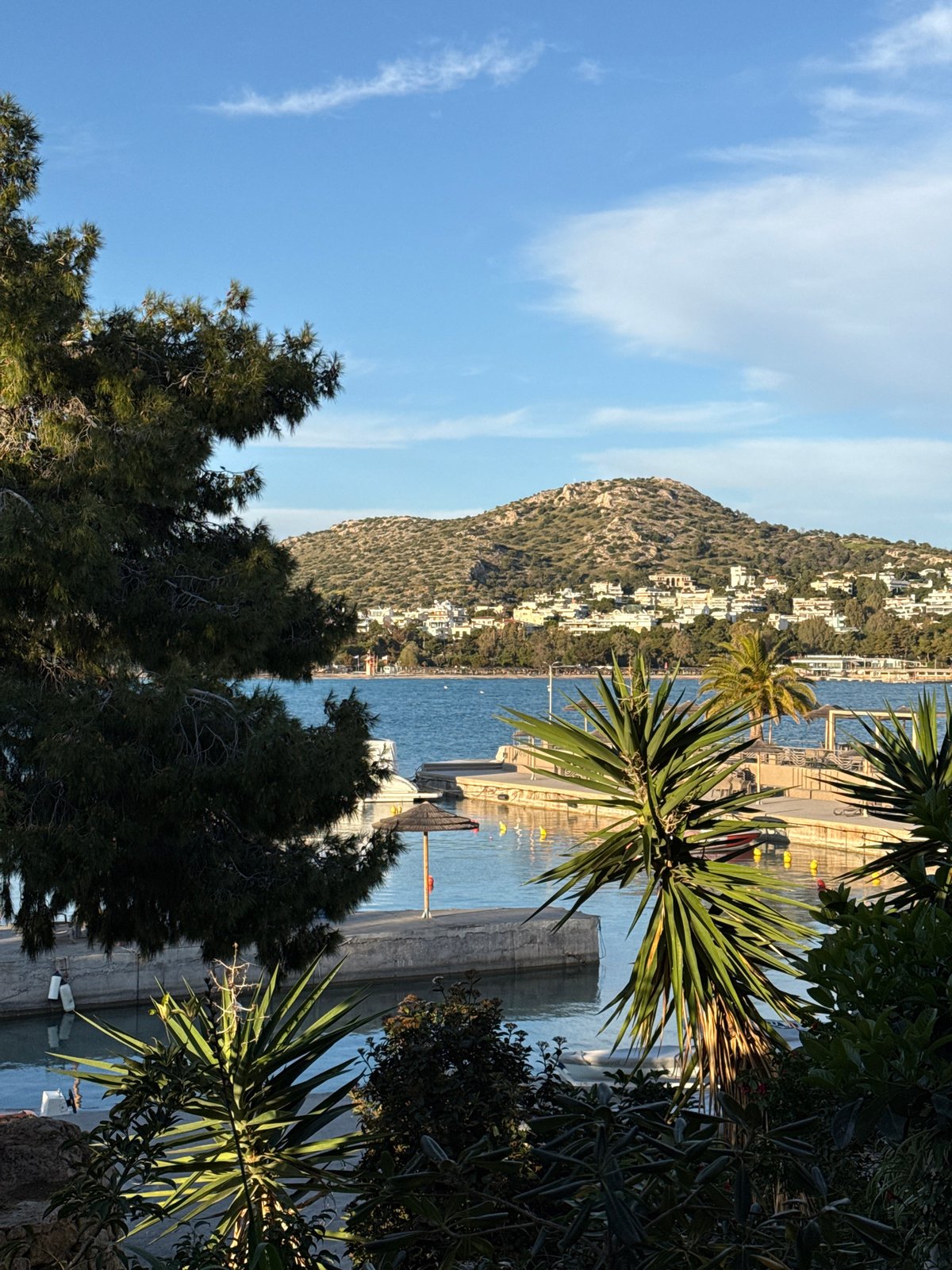 Tourists photograph scenic coastal views in Vouliagmeni, Greece