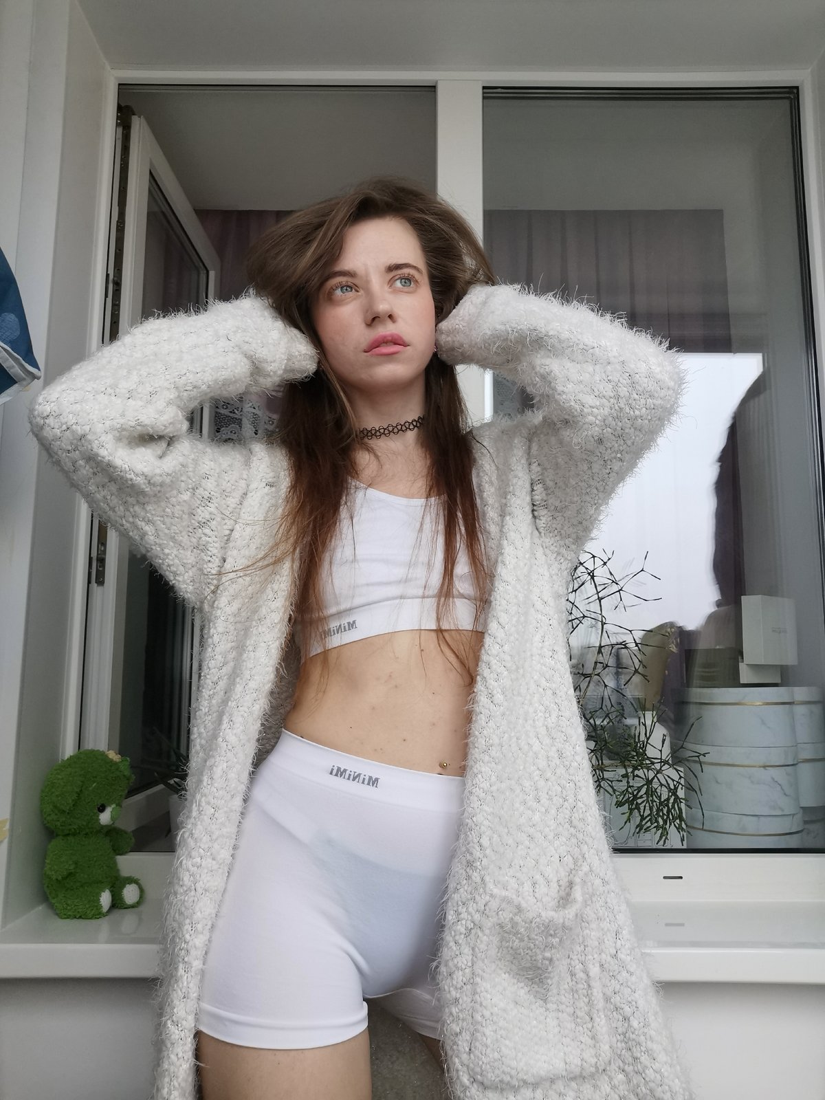 Woman poses for indoor photo session in white athletic wear