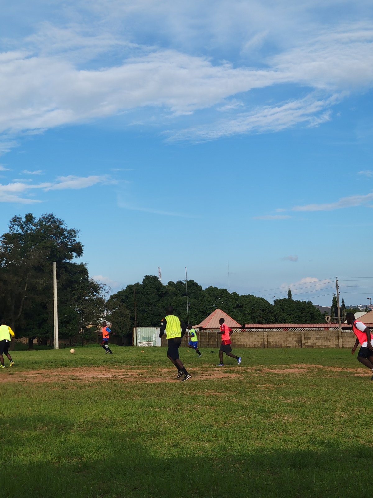 Afternoon soccer practice on a Jos field