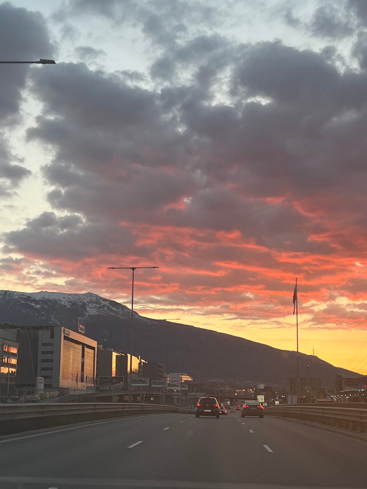 Dramatic cloudy skies over snow-capped mountains from Sofia highway