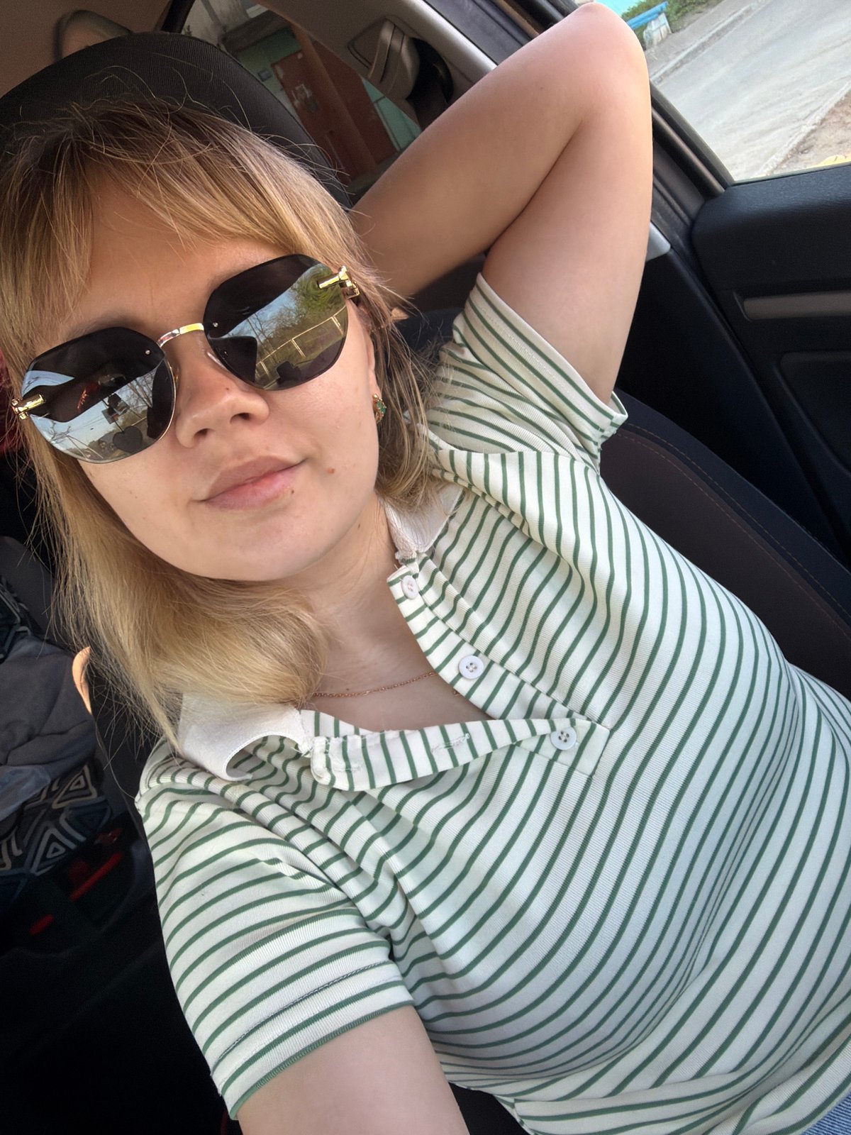 Person in sunglasses relaxes in car seat, Chaikovsky Russia