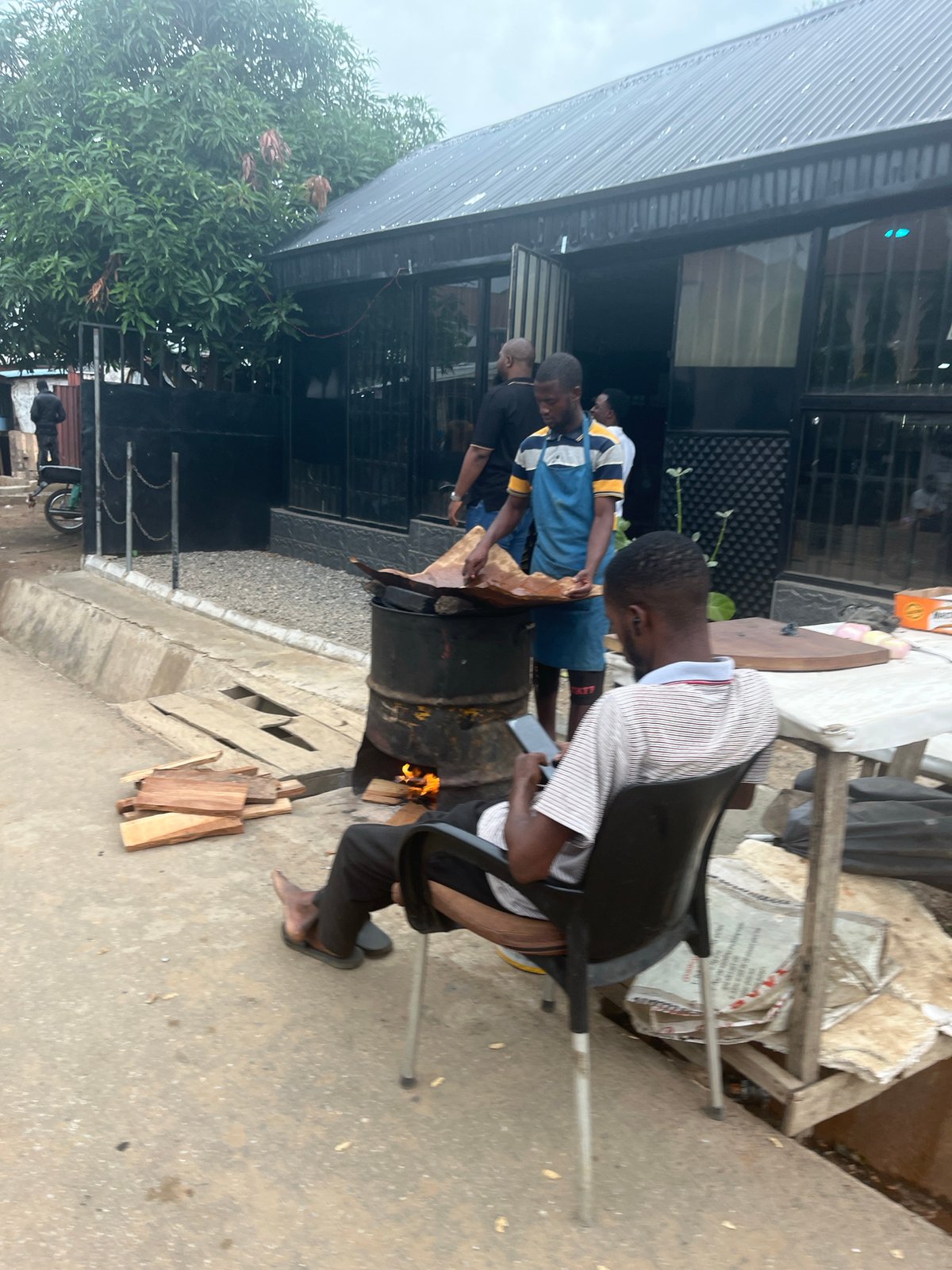 Everyday street life and vendors along a dusty Abuja corridor