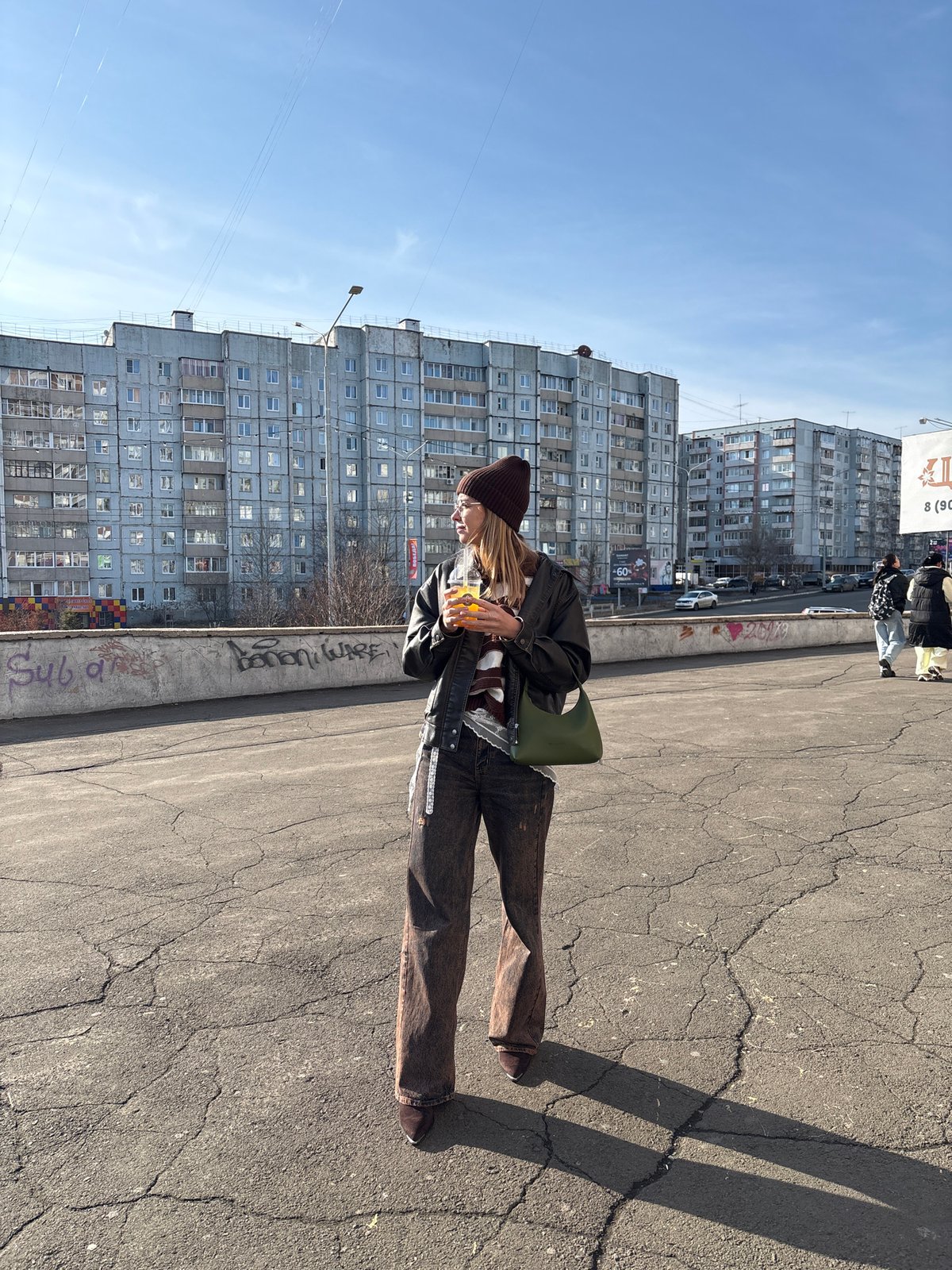 Woman photographed with beverage in Ust-Ilimsk on sunny day