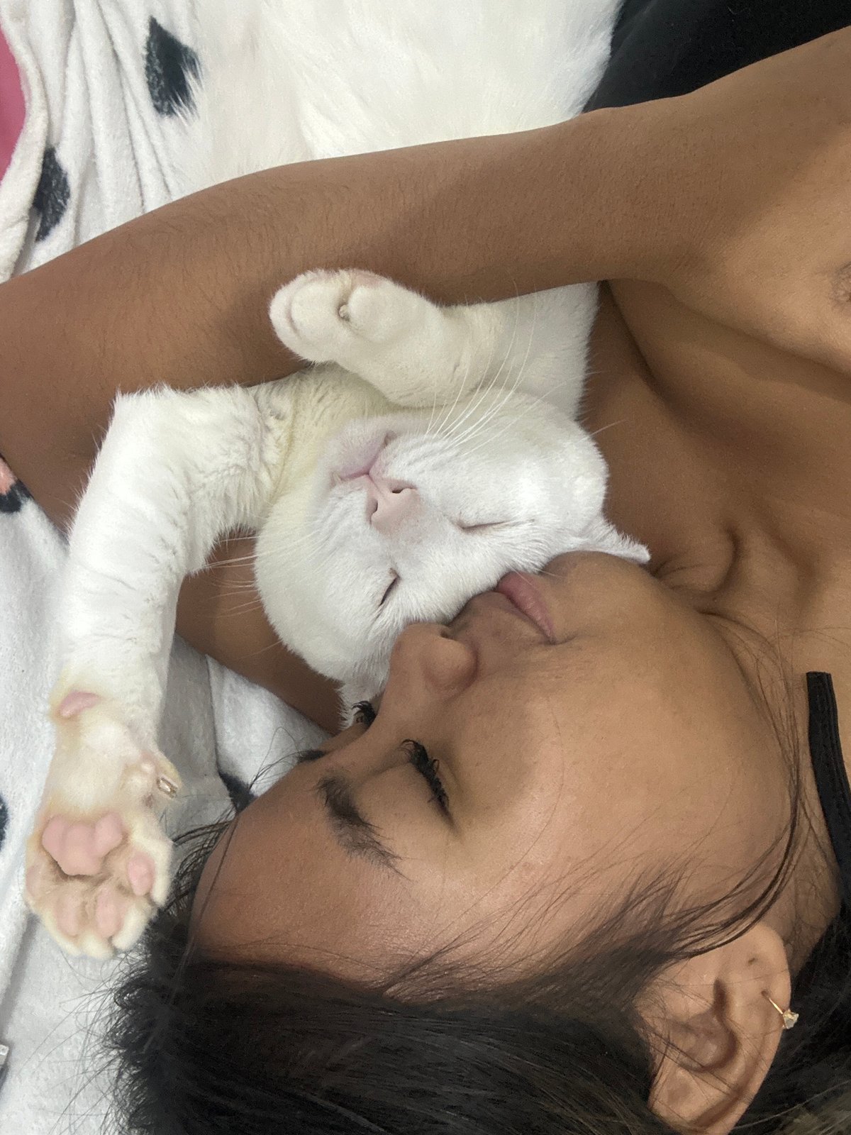 Person and white cat share quiet afternoon moments in Sukawati