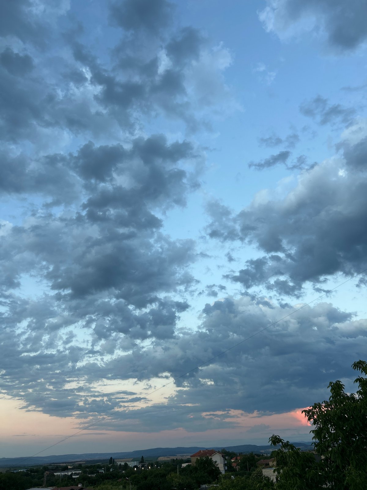 Dusk settles over urban outskirts under a dramatic cloudy sky