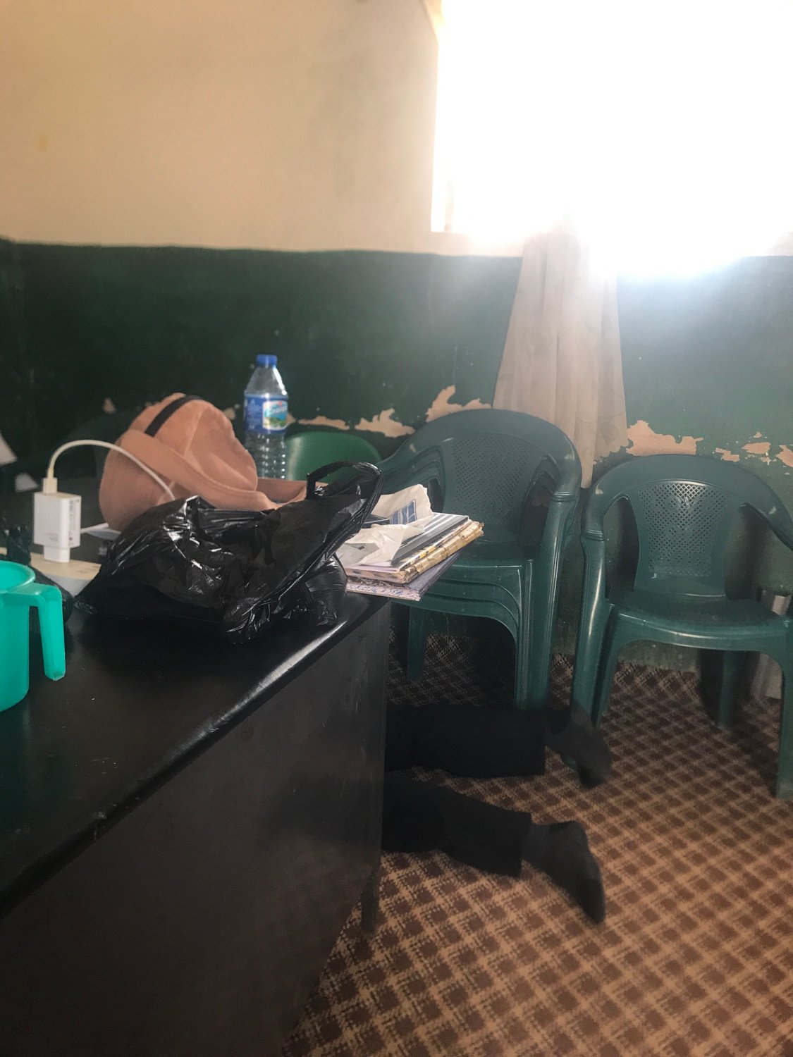 Person documents cluttered room filled with white plastic sacks