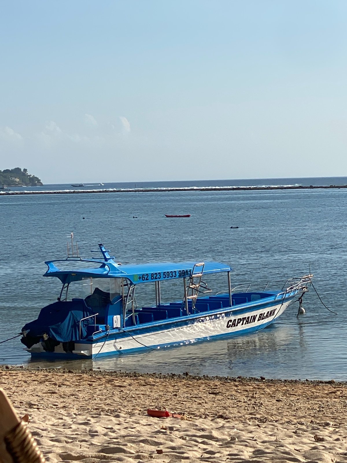 Quiet morning at a Nusa Penida beach with boats and shoreline scenes