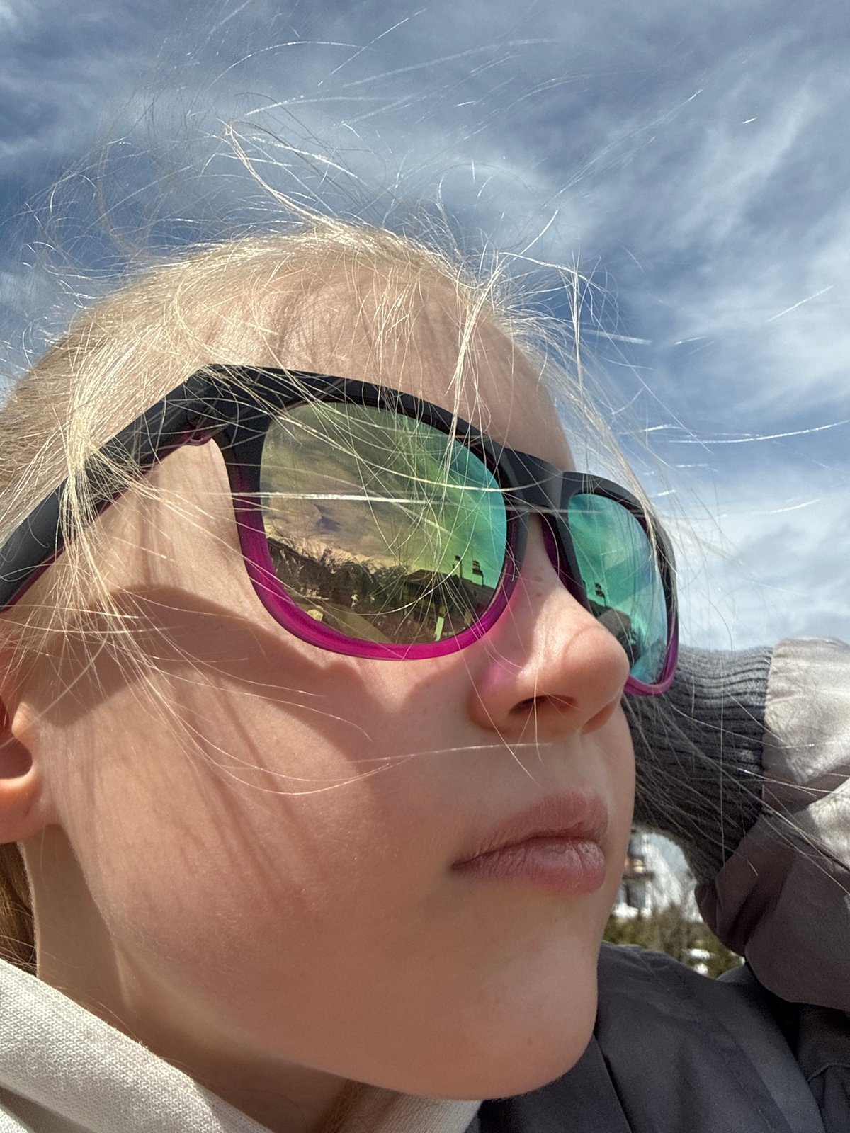 Blonde person in sunglasses photographed looking skyward in Russia