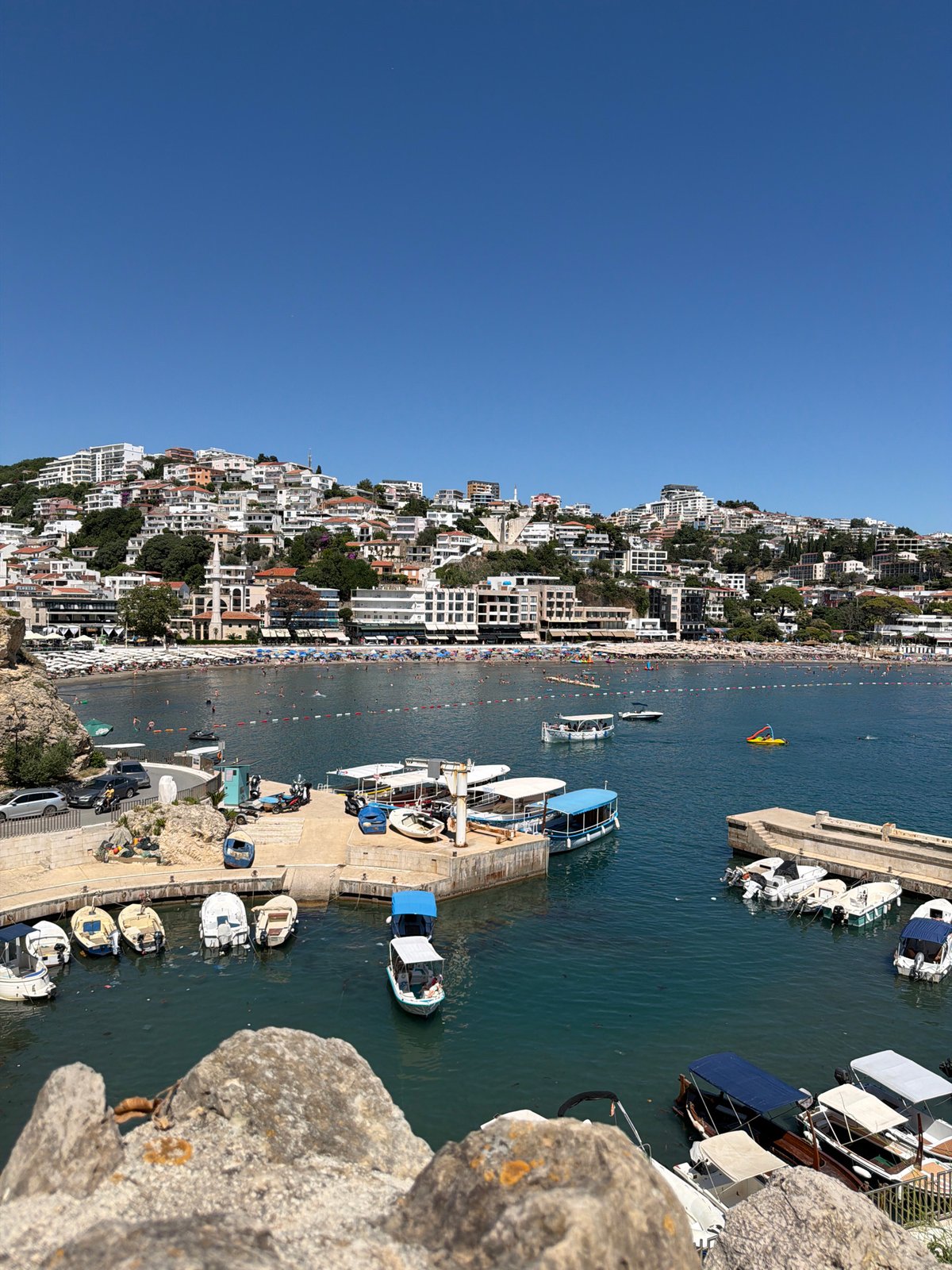 Ulcinj summer: packed beach, jet skis, and napping cats