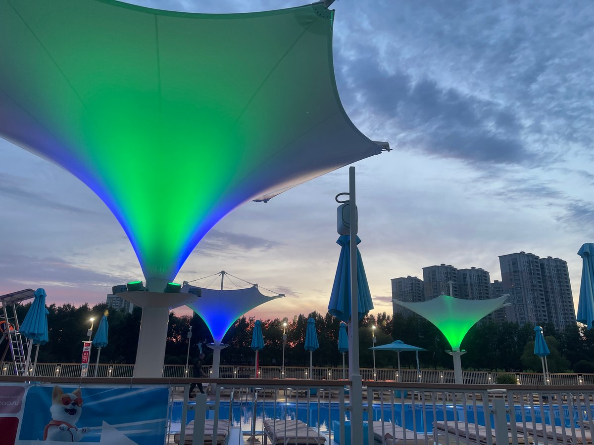 Moscow waterfront at dusk: pools, decks, and a summer sky