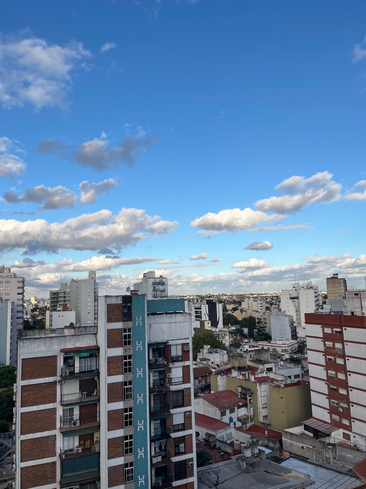 Elevated cityscape view captured showing mixed architecture under cloudy skies