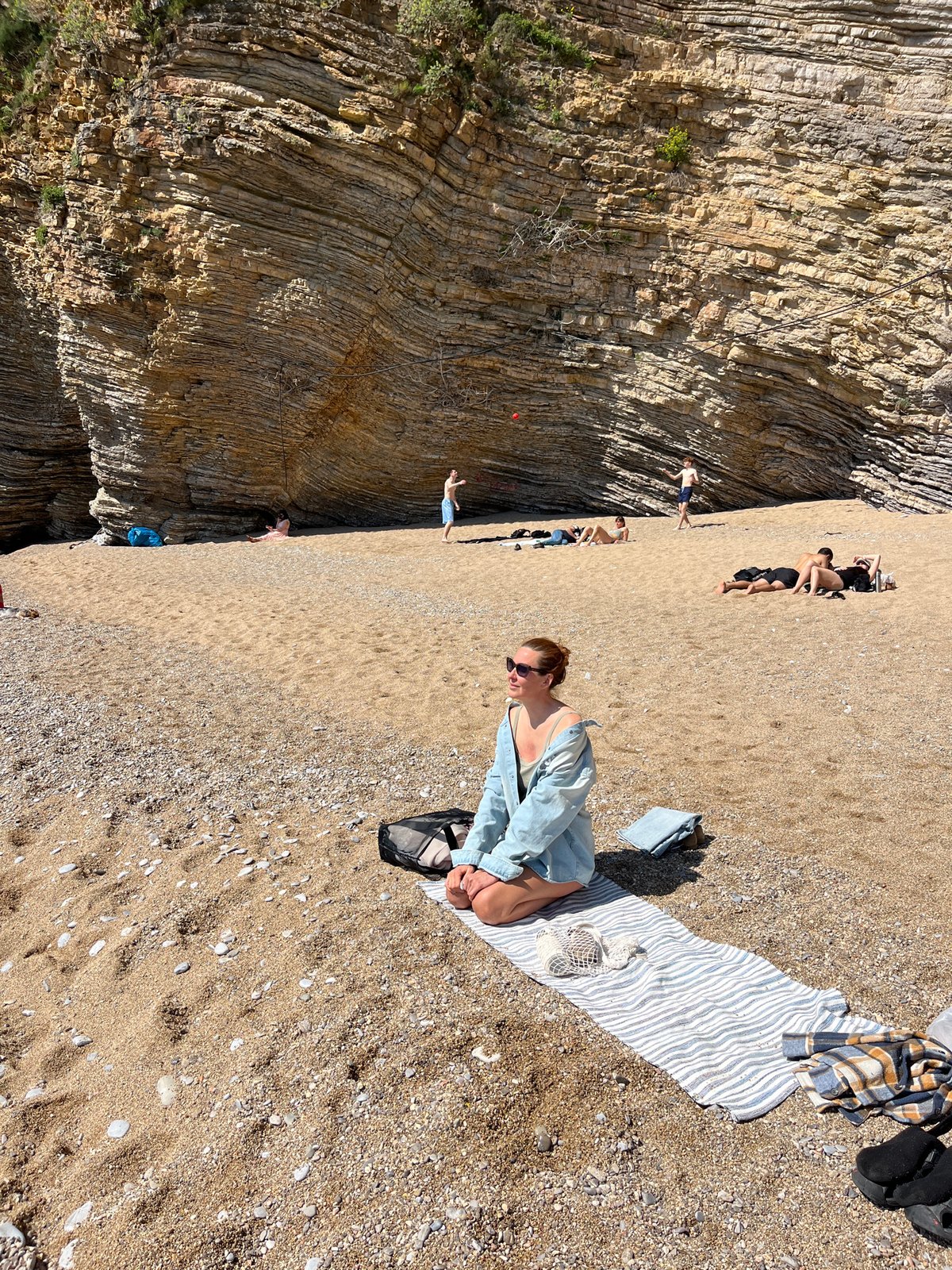Beach scene documented in Budva showing geological rock formations