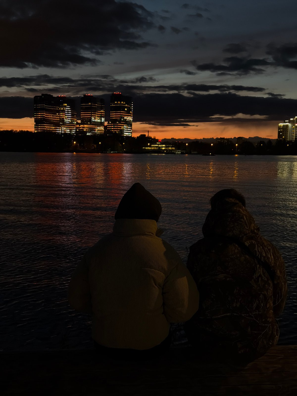 Evening riverside gathering captured in illuminated Kazan cityscape