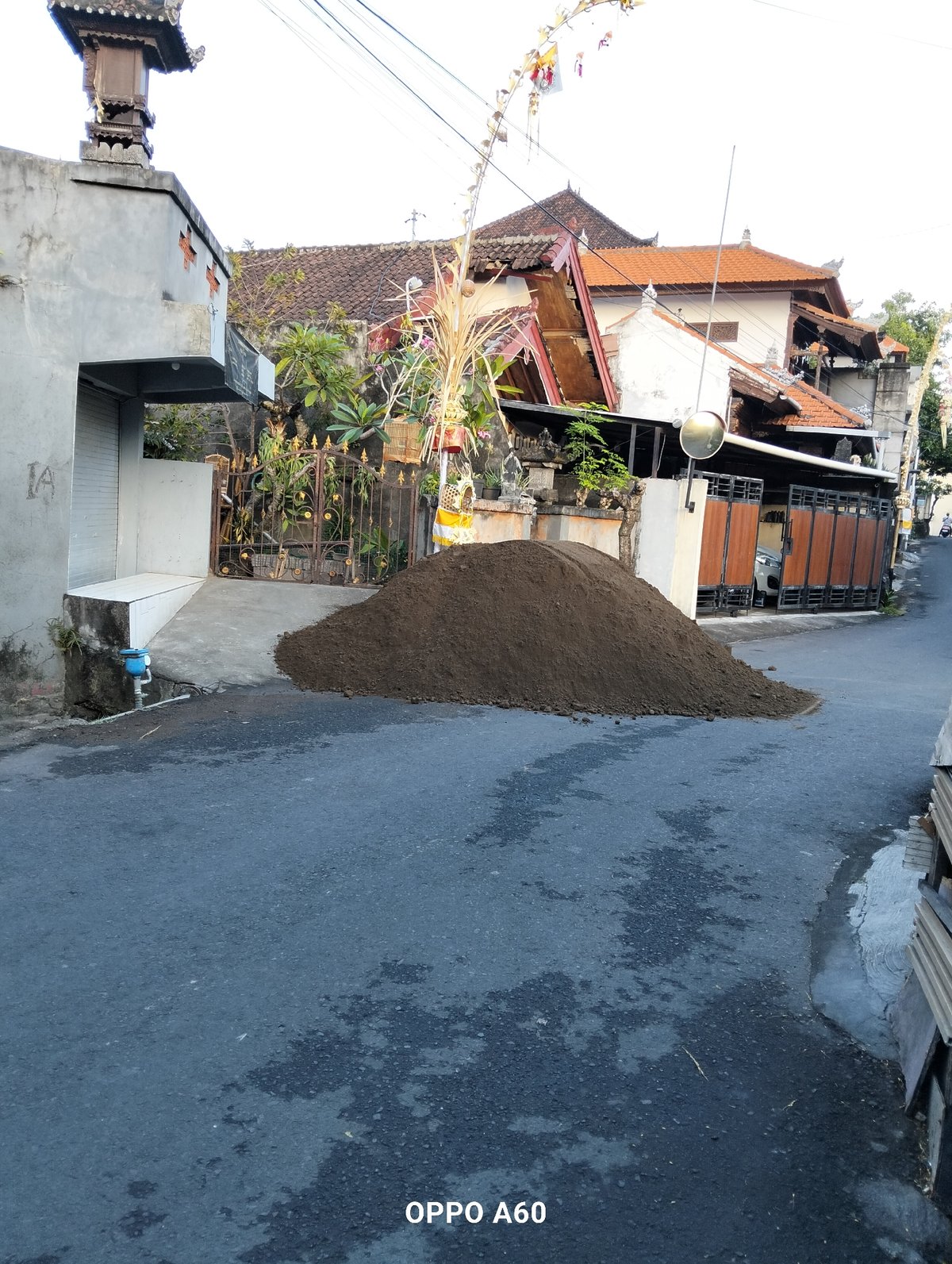 Soil delivery disrupts a North Kuta street amid market day scenes