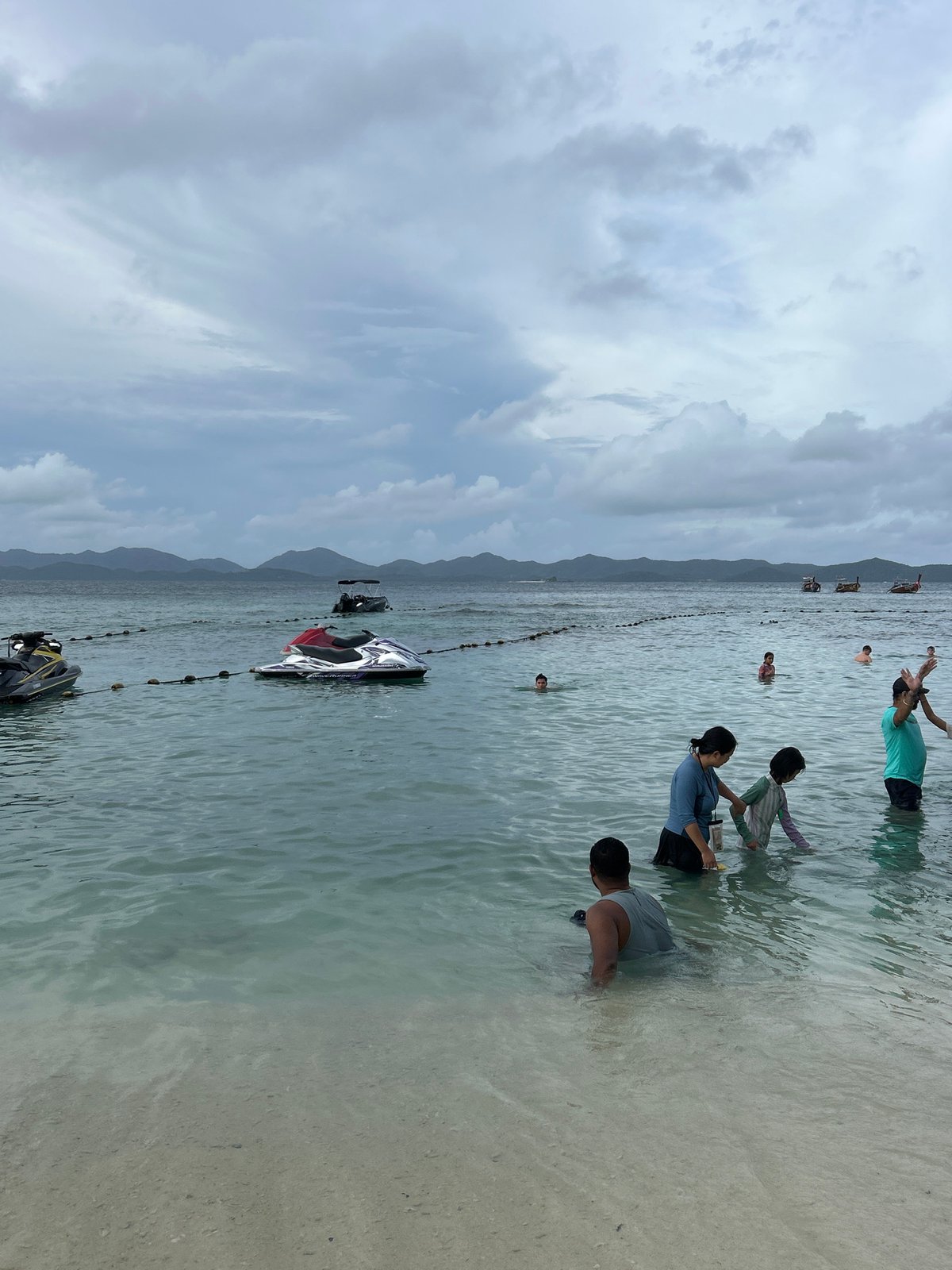Crowded beach morning in Phru Nai with jet skis and families